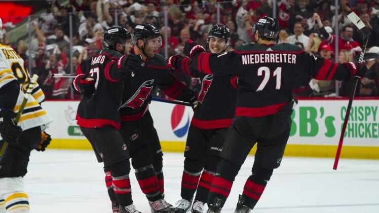 May 4, 2022; Raleigh, North Carolina, USA; Carolina Hurricanes right wing Jesper Fast (71) is congratulated by right wing Nino Niederreiter (21) defenseman Tony DeAngelo (77) and center Jordan Staal (11) after his goal against the Boston Bruins during the first period in game two of the first round of the 2022 Stanley Cup Playoffs at PNC Arena. Mandatory Credit: James Guillory-USA TODAY Sports