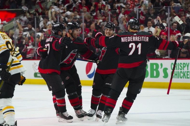 May 4, 2022; Raleigh, North Carolina, USA; Carolina Hurricanes right wing Jesper Fast (71) is congratulated by right wing Nino Niederreiter (21) defenseman Tony DeAngelo (77) and center Jordan Staal (11) after his goal against the Boston Bruins during the first period in game two of the first round of the 2022 Stanley Cup Playoffs at PNC Arena. Mandatory Credit: James Guillory-USA TODAY Sports