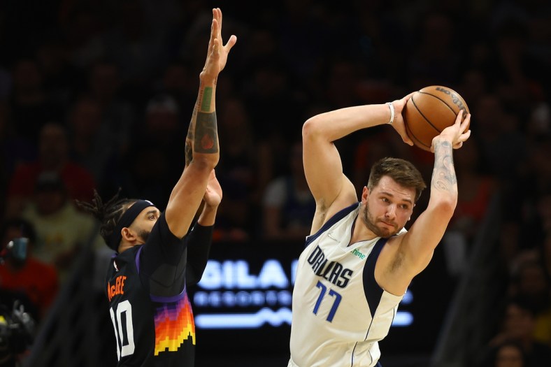 May 4, 2022; Phoenix, Arizona, USA; Dallas Mavericks guard Luka Doncic (77) controls the ball against Phoenix Suns center JaVale McGee (00) during the first half in game two of the second round for the 2022 NBA playoffs at Footprint Center. Mandatory Credit: Mark J. Rebilas-USA TODAY Sports