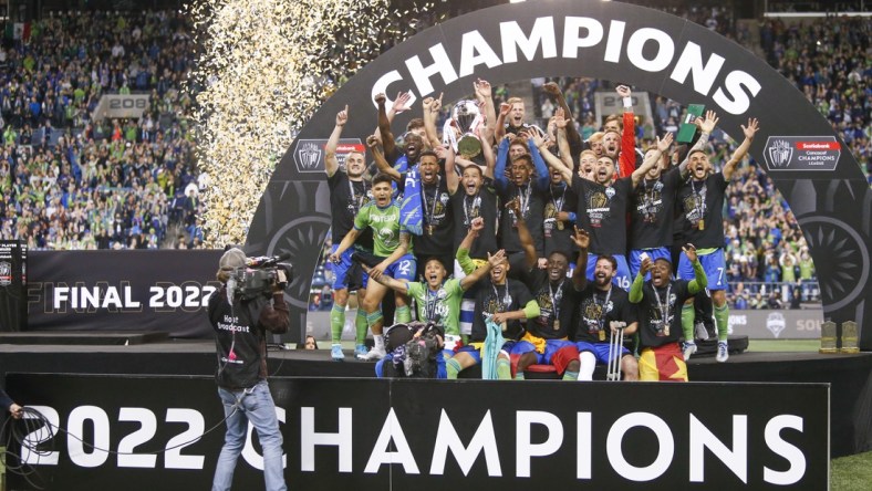 May 4, 2022; Seattle, WA, USA; Seattle Sounders FC players, including midfielder Nicolas Lodeiro (10, holding trophy) celebrate after defeating Pumas 3-0 in the second leg of the Concacaf Champions League Final at Lumen Field. Mandatory Credit: Joe Nicholson-USA TODAY Sports