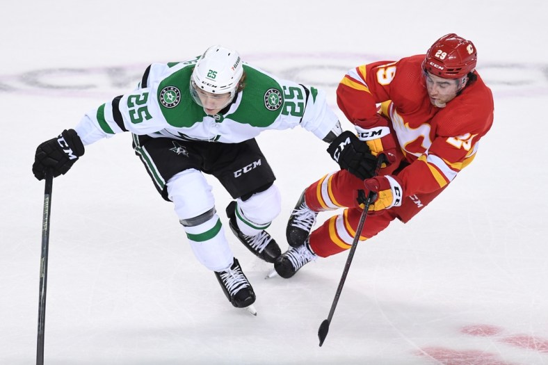 May 5, 2022; Calgary, Alberta, CAN; Dallas Stars forward Joel Kiviranta (25) and Calgary Flames forward Dillon Dube (29) battle for the puck in game two of the first round of the 2022 Stanley Cup Playoffs at Scotiabank Saddledome. Mandatory Credit: Candice Ward-USA TODAY Sports
