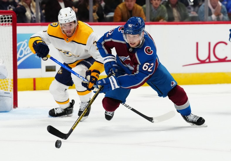 May 5, 2022; Denver, Colorado, USA; Nashville Predators defenseman Jeremy Lauzon (3) and Colorado Avalanche left wing Artturi Lehkonen (62) reach for the puck in the second period of game two of the first round of the 2022 Stanley Cup Playoffs at Ball Arena. Mandatory Credit: Ron Chenoy-USA TODAY Sports