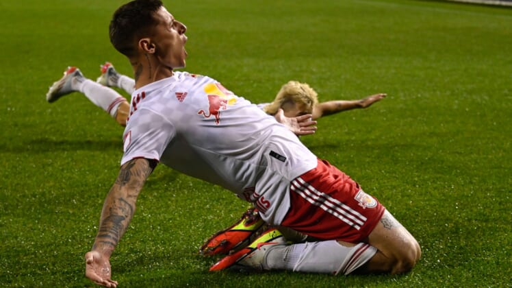 Apr 30, 2022; Chicago, Illinois, USA;  New York Red Bulls forward Patryk Klimala (9), left, and New York Red Bulls defender John Tolkin (47) slide on the field after Klimala scored a goal during the second half against the Chicago Fire at Soldier Field. Mandatory Credit: Matt Marton-USA TODAY Sports