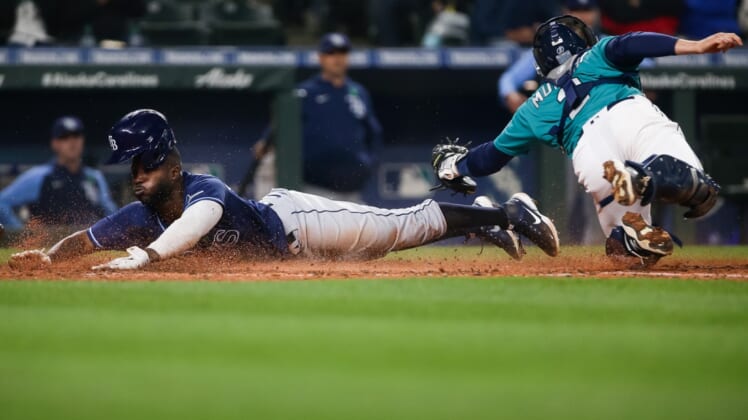 May 6, 2022; Seattle, Washington, USA;  Tampa Bay Rays designated hitter Randy Arozarena (56) scores on a throwing error by Seattle Mariners third baseman Eugenio Suarez (not pictured) ahead of the tag from catcher Tom Murphy (2) during the fifth inning at T-Mobile Park. Mandatory Credit: Lindsey Wasson-USA TODAY Sports