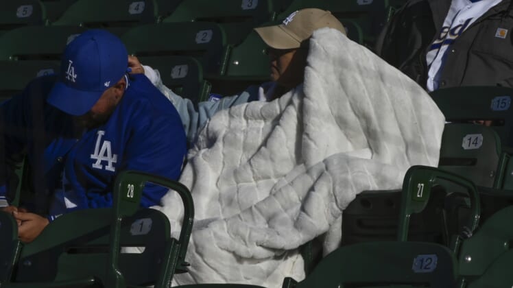 May 7, 2022; Chicago, Illinois, USA;  A Los Angeles Dodgers fans tries to stay warm under a blanket before game two of a double header between the Chicago Cubs and the Los Angeles Dodgers at Wrigley Field. Mandatory Credit: Matt Marton-USA TODAY Sports