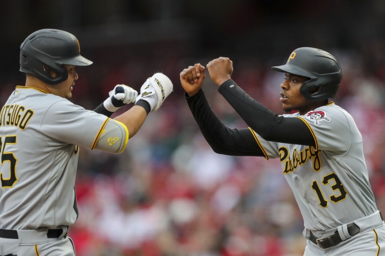May 7, 2022; Cincinnati, Ohio, USA; Pittsburgh Pirates first baseman Yoshi Tsutsugo (25) high fives third baseman Ke'Bryan Hayes (13) after hitting a solo home run against the Cincinnati Reds in the first inning at Great American Ball Park. Mandatory Credit: Katie Stratman-USA TODAY Sports