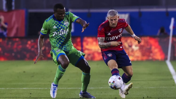 May 7, 2022; Frisco, Texas, USA;  FC Dallas forward Paul Arriola (7) kicks the balll away from Seattle Sounders defender Nouhou Tolo (5) during the first half at Toyota Stadium. Mandatory Credit: Kevin Jairaj-USA TODAY Sports