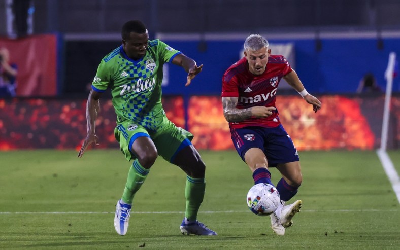 May 7, 2022; Frisco, Texas, USA;  FC Dallas forward Paul Arriola (7) kicks the balll away from Seattle Sounders defender Nouhou Tolo (5) during the first half at Toyota Stadium. Mandatory Credit: Kevin Jairaj-USA TODAY Sports