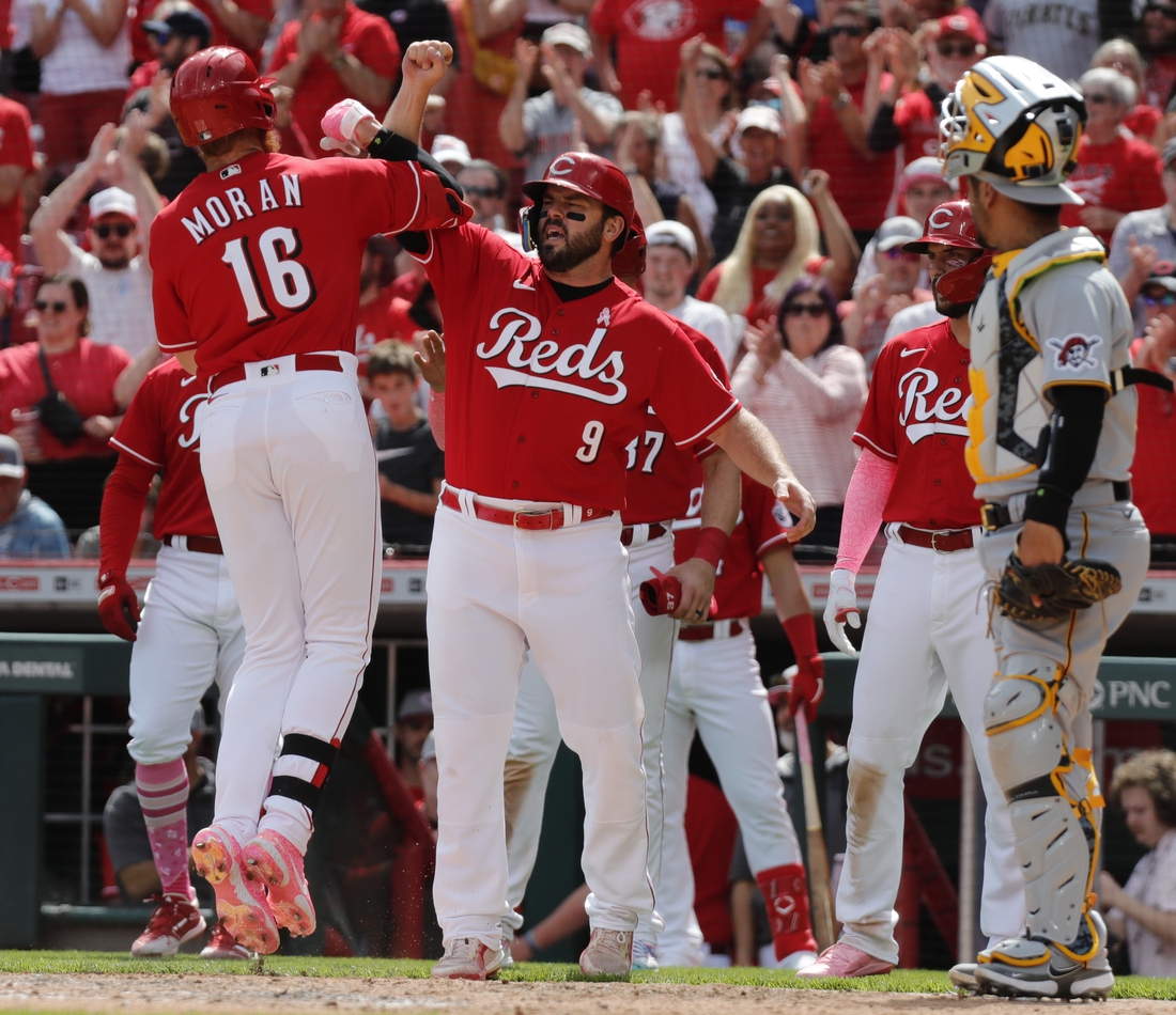 May 8, 2022; Cincinnati, Ohio, USA; Cincinnati Reds first baseman Colin Moran (16) reacts with designated hitter Mike Moustakas (9) after hitting a grand slam against the Pittsburgh Pirates during the sixth inning at Great American Ball Park. Mandatory Credit: David Kohl-USA TODAY Sports