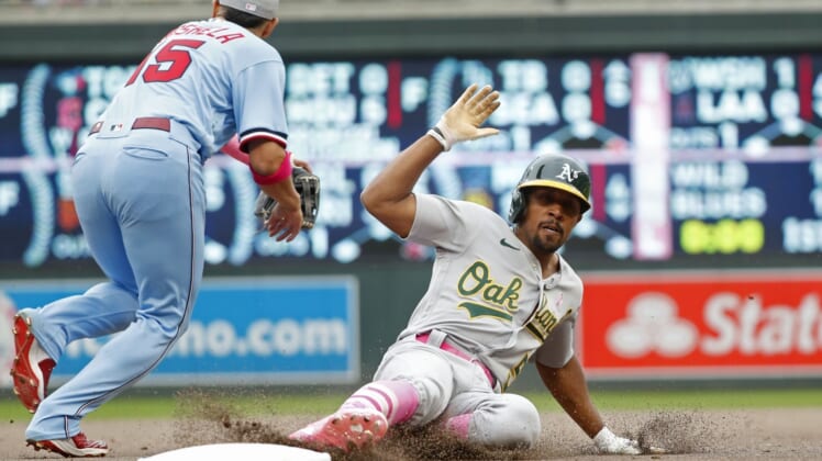 May 8, 2022; Minneapolis, Minnesota, USA; Oakland Athletics pinch hitter Tony Kemp (5) slides into third base as he advances on a fly out and Minnesota Twins third baseman Gio Urshela (15) goes for the throw in the ninth inning at Target Field. Mandatory Credit: Bruce Kluckhohn-USA TODAY Sports