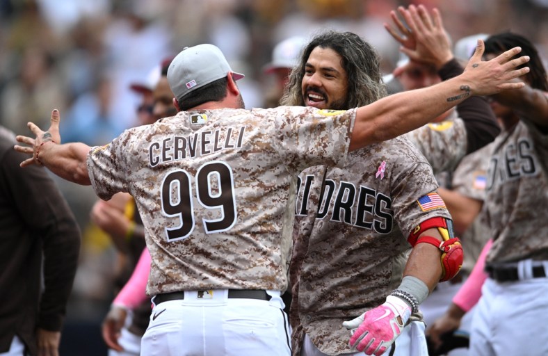 May 8, 2022; San Diego, California, USA; San Diego Padres pinch-hitter Jorge Alfaro (38) is embraced by catching coach Francisco Cwervelli (99) after hitting a walk-off three-run home run during the ninth inning against the Miami Marlins at Petco Park. Mandatory Credit: Orlando Ramirez-USA TODAY Sports