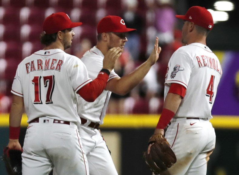 May 9, 2022; Cincinnati, Ohio, USA; Cincinnati Reds third baseman Brandon Drury (middle) reacts with shortstop Kyle Farmer (17) and second baseman Matt Reynolds (4) after the Reds defeated the Milwaukee Brewers at Great American Ball Park. Mandatory Credit: David Kohl-USA TODAY Sports