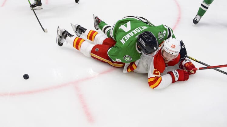 May 9, 2022; Dallas, Texas, USA; Dallas Stars defenseman Miro Heiskanen (4) takes down Calgary Flames center Trevor Lewis (22) during the second period in game four of the first round of the 2022 Stanley Cup Playoffs at American Airlines Center. Mandatory Credit: Jerome Miron-USA TODAY Sports