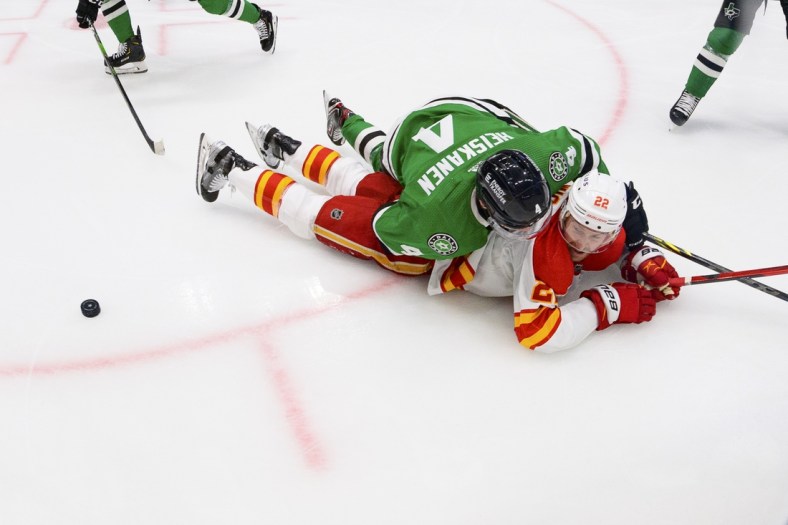 May 9, 2022; Dallas, Texas, USA; Dallas Stars defenseman Miro Heiskanen (4) takes down Calgary Flames center Trevor Lewis (22) during the second period in game four of the first round of the 2022 Stanley Cup Playoffs at American Airlines Center. Mandatory Credit: Jerome Miron-USA TODAY Sports