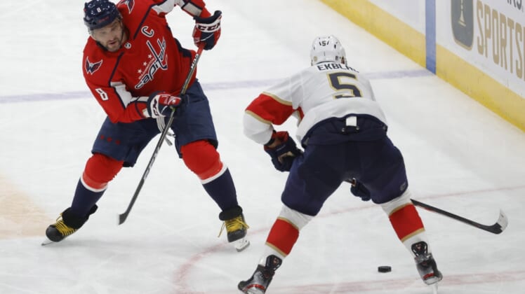 May 9, 2022; Washington, District of Columbia, USA; Washington Capitals left wing Alex Ovechkin (8) attempts to skate with the puck around Florida Panthers defenseman Aaron Ekblad (5) in the third period in game four of the first round of the 2022 Stanley Cup Playoffs at Capital One Arena. Mandatory Credit: Geoff Burke-USA TODAY Sports