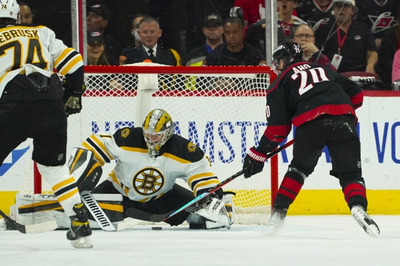 May 10, 2022; Raleigh, North Carolina, USA; Carolina Hurricanes center Sebastian Aho (20) goes for the puck against Boston Bruins goaltender Jeremy Swayman (1) during the second period in game five of the first round of the 2022 Stanley Cup Playoffs at PNC Arena. Mandatory Credit: James Guillory-USA TODAY Sports