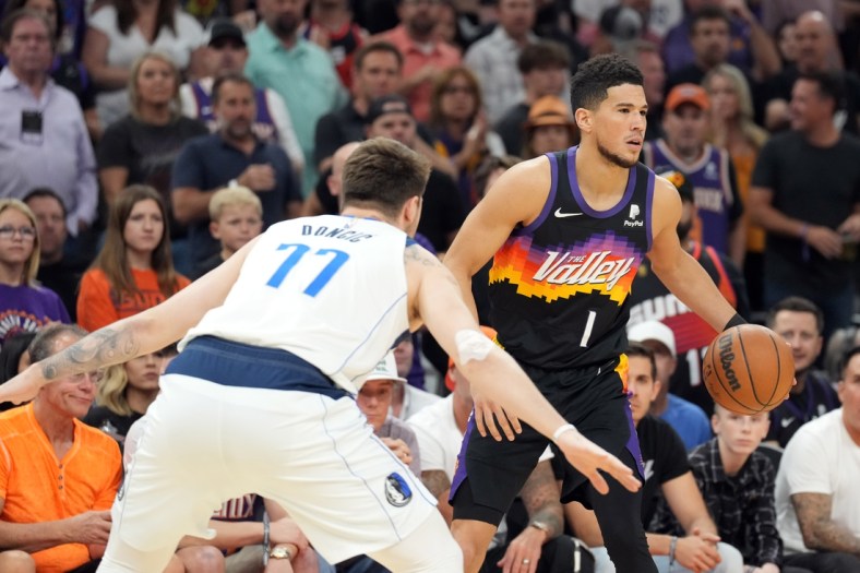 May 10, 2022; Phoenix, Arizona, USA; Phoenix Suns guard Devin Booker (1) dribbles against Dallas Mavericks guard Luka Doncic (77) during the first half of game five of the second round for the 2022 NBA playoffs at Footprint Center. Mandatory Credit: Joe Camporeale-USA TODAY Sports