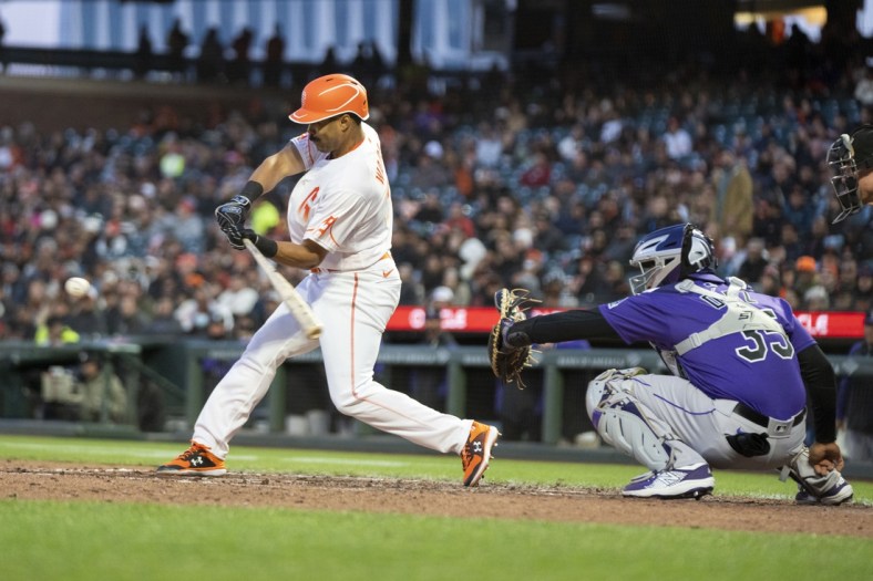 May 10, 2022; San Francisco, California, USA; San Francisco Giants right fielder LaMonte Wade Jr. (left) grounds into a force out scoring left fielder Luis Gonzalez (not pictured) against Colorado Rockies catcher Elias Diaz (right) during the fourth inning at Oracle Park. Mandatory Credit: Kyle Terada-USA TODAY Sports