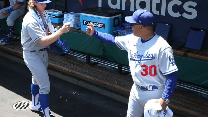 May 11, 2022; Pittsburgh, Pennsylvania, USA;  Los Angeles Dodgers starting pitcher Ryan Pepiot (left) fist bumps manager Dave Roberts (30) in the dugout before making his major league debut against the Pittsburgh Pirates at PNC Park. Mandatory Credit: Charles LeClaire-USA TODAY Sports