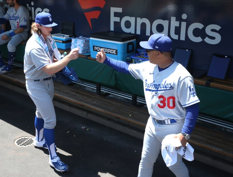 May 11, 2022; Pittsburgh, Pennsylvania, USA;  Los Angeles Dodgers starting pitcher Ryan Pepiot (left) fist bumps manager Dave Roberts (30) in the dugout before making his major league debut against the Pittsburgh Pirates at PNC Park. Mandatory Credit: Charles LeClaire-USA TODAY Sports