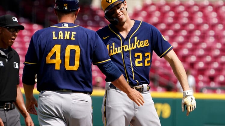 Milwaukee Brewers left fielder Christian Yelich (22) is congratulated by Milwaukee Brewers third base coach Jason Lane (40) after hitting a triple to hit for a cycle, in the ninth inning of a baseball game, Wednesday, May 11, 2022, at Great American Ball Park in Cincinnati. The Cincinnati Reds won, 14-11.Milwaukee Brewers At Cincinnati Reds May 11 0055
