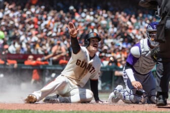May 11, 2022; San Francisco, California, USA;  San Francisco Giants center Mike Yastrzemski (5) reacts as he slides home to score against Colorado Rockies catcher Dom Nunez (3) during the fourth inning at Oracle Park. Mandatory Credit: John Hefti-USA TODAY Sports