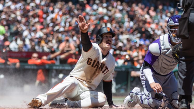 May 11, 2022; San Francisco, California, USA;  San Francisco Giants center Mike Yastrzemski (5) reacts as he slides home to score against Colorado Rockies catcher Dom Nunez (3) during the fourth inning at Oracle Park. Mandatory Credit: John Hefti-USA TODAY Sports