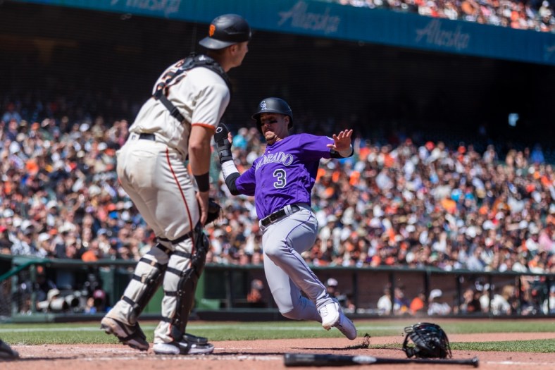May 11, 2022; San Francisco, California, USA;  Colorado Rockies catcher Dom Nunez (3) slides home to score against San Francisco Giants catcher Joey Bart (21) during the sixth inning at Oracle Park. Mandatory Credit: John Hefti-USA TODAY Sports