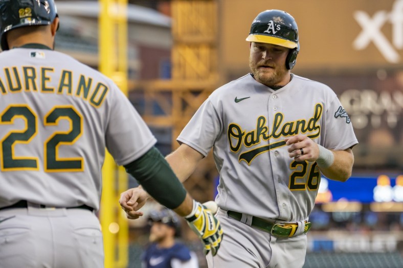 May 11, 2022; Detroit, Michigan, USA; Oakland Athletics designated hitter Sheldon Neuse (26) celebrates with right fielder Ramon Laureano (22) after scoring a run during the third inning against the Detroit Tigers at Comerica Park. Mandatory Credit: Raj Mehta-USA TODAY Sports