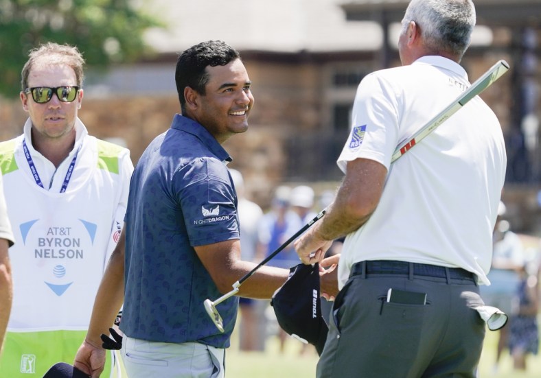 May 12, 2022; McKinney, Texas, USA; Sebastian Munoz shakes the hand of playing partner Matt Kuchar on the 18th green after completing his 12-under round of 60 during the first round of the AT&T Byron Nelson golf tournament. Mandatory Credit: Raymond Carlin III-USA TODAY Sports
