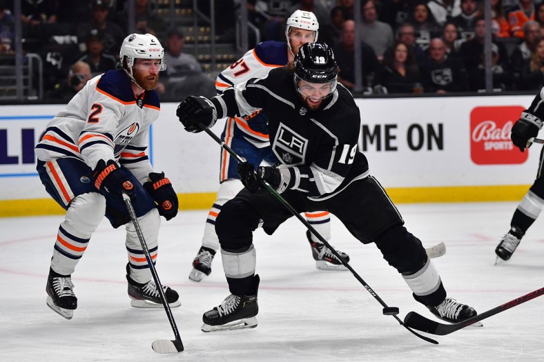 May 12, 2022; Los Angeles, California, USA; Los Angeles Kings left wing Alex Iafallo (19) plays for the puck against Edmonton Oilers defenseman Duncan Keith (2) during the second period in game six of the first round of the 2022 Stanley Cup Playoffs at Crypto.com Arena. Mandatory Credit: Gary A. Vasquez-USA TODAY Sports