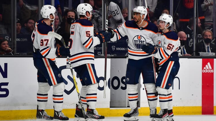 May 12, 2022; Los Angeles, California, USA; Edmonton Oilers left wing Evander Kane (91) celebrates with center Connor McDavid (97) defenseman Cody Ceci (5) and right wing Kailer Yamamoto (56) his empty net goal scored against the Los Angeles Kings during the third period in game six of the first round of the 2022 Stanley Cup Playoffs at Crypto.com Arena. Mandatory Credit: Gary A. Vasquez-USA TODAY Sports