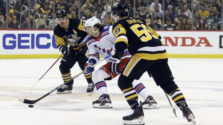 May 13, 2022; Pittsburgh, Pennsylvania, USA;  New York Rangers left wing Artemi Panarin (10) moves the puck between Pittsburgh Penguins center Evgeni Malkin (71) and left wing Jake Guentzel (59) during the first period in game six of the first round of the 2022 Stanley Cup Playoffs at PPG Paints Arena. Mandatory Credit: Charles LeClaire-USA TODAY Sports