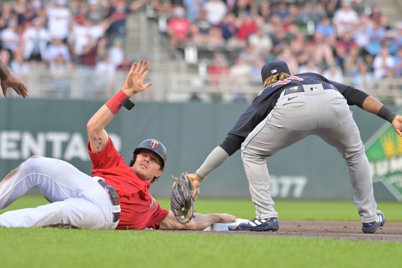 May 13, 2022; Minneapolis, Minnesota, USA; Minnesota Twins right fielder Max Kepler (26) slides in safe in front of Cleveland Guardians third baseman Jose Ramirez (11) during the first inning at Target Field. Mandatory Credit: Jeffrey Becker-USA TODAY Sports