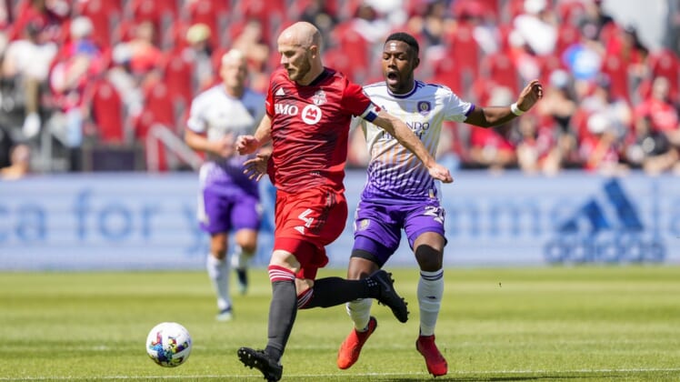 May 14, 2022; Toronto, Ontario, CAN; Toronto FC midfielder Michael Bradley (4) wins the ball off Orlando City midfielder Andr  s Perea (21) during the first half at BMO Field. Mandatory Credit: Kevin Sousa-USA TODAY Sports