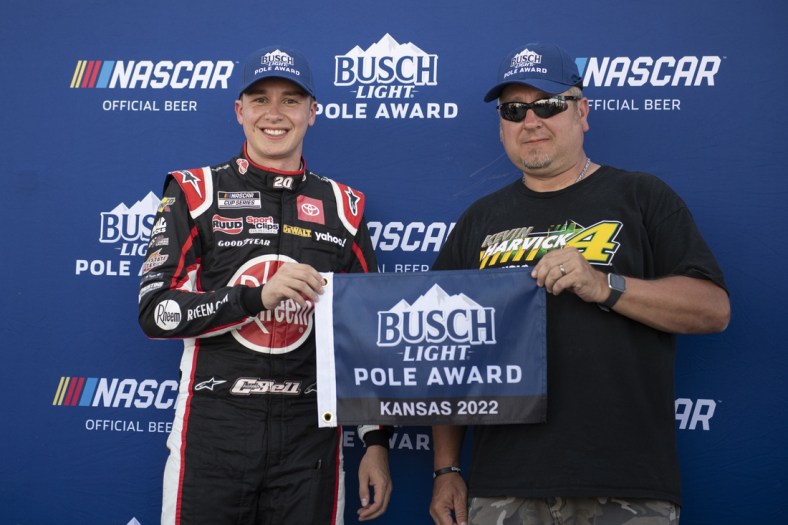 May 14, 2022; Kansas City, Kansas, USA; NASCAR Cup Series driver Christopher Bell (left) reacts after securing the pole position during AdventHealth 400 qualifying at Kansas Speedway. Mandatory Credit: Amy Kontras-USA TODAY Sports