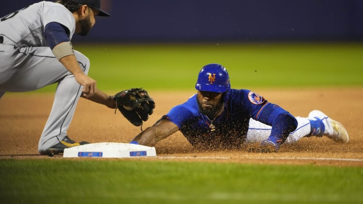 May 14, 2022; New York City, New York, USA; New York Mets right fielder Starling Marte (6) dives into third base safely ahead of the tag by Seattle Mariners third baseman Eugenio Suarez (28) with a triple during the first inning at Citi Field. Mandatory Credit: Gregory Fisher-USA TODAY Sports