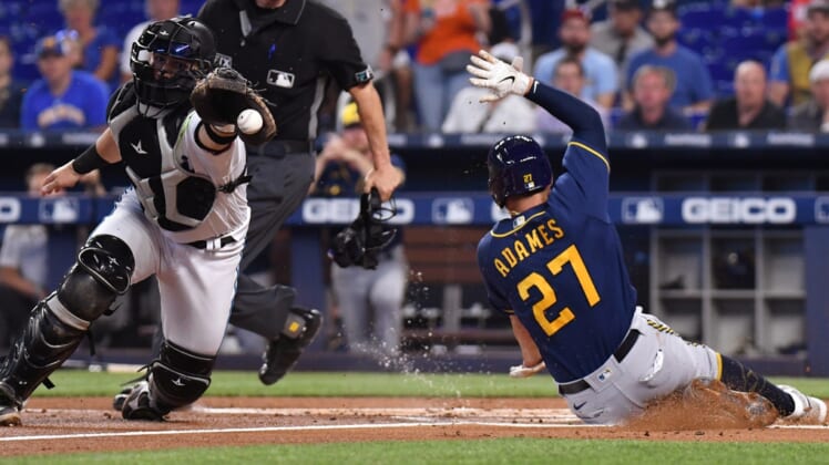 May 15, 2022; Miami, Florida, USA; Milwaukee Brewers Willy Adames (27) slides ahead of the throw received by  Miami Marlins catcher Payton Henry (59) during the first inning at loanDepot Park. Mandatory Credit: Jim Rassol-USA TODAY Sports