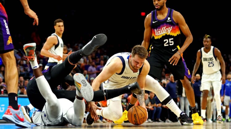 May 15, 2022; Phoenix, Arizona, USA; Dallas Mavericks guard Luka Doncic (77) goes for a ball against Phoenix Suns forward Mikal Bridges (25) during the second quarter in game seven of the second round for the 2022 NBA playoffs at Footprint Center. Mandatory Credit: Mark J. Rebilas-USA TODAY Sports