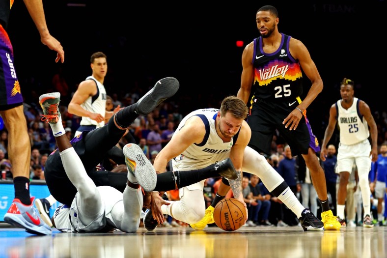 May 15, 2022; Phoenix, Arizona, USA; Dallas Mavericks guard Luka Doncic (77) goes for a ball against Phoenix Suns forward Mikal Bridges (25) during the second quarter in game seven of the second round for the 2022 NBA playoffs at Footprint Center. Mandatory Credit: Mark J. Rebilas-USA TODAY Sports