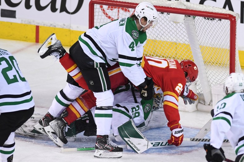 May 15, 2022; Calgary, Alberta, CAN; Calgary Flames forward Blake Coleman (20) collides with defenseman Miro Heiskanen (4) and goalie Jake Oettinger (29) during the second period in game seven of the first round of the 2022 Stanley Cup Playoffs at Scotiabank Saddledome. Mandatory Credit: Candice Ward-USA TODAY Sports
