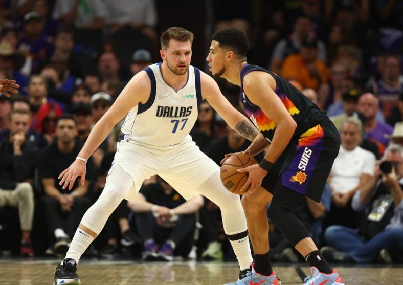 May 15, 2022; Phoenix, Arizona, USA; Dallas Mavericks guard Luka Doncic (77) against Phoenix Suns guard Devin Booker (1) in game seven of the second round for the 2022 NBA playoffs at Footprint Center. Mandatory Credit: Mark J. Rebilas-USA TODAY Sports