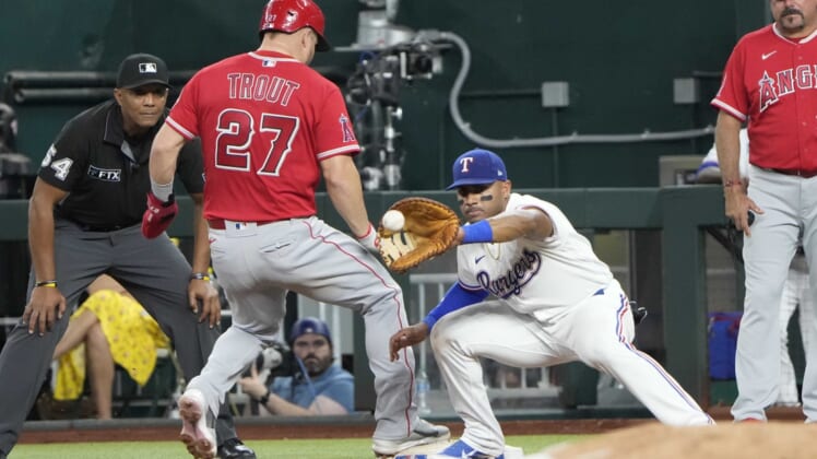 May 17, 2022; Arlington, Texas, USA; Los Angeles Angels center fielder Mike Trout (27) beats the throw to Texas Rangers first baseman Andy Ibanez (77) on a pick off attempt during the fifth inning of a baseball game at Globe Life Field. Mandatory Credit: Jim Cowsert-USA TODAY Sports