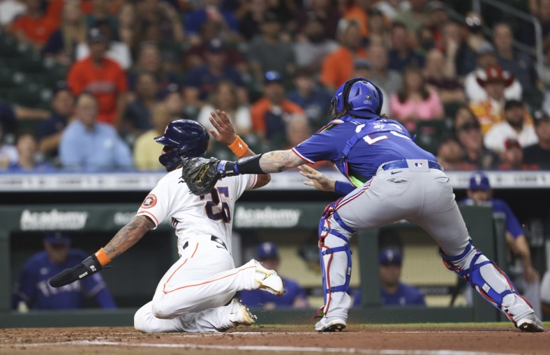May 19, 2022; Houston, Texas, USA; Texas Rangers catcher Jonah Heim (28) tags out Houston Astros center fielder Jose Siri (26) at home plate in the second inning at Minute Maid Park. Mandatory Credit: Thomas Shea-USA TODAY Sports