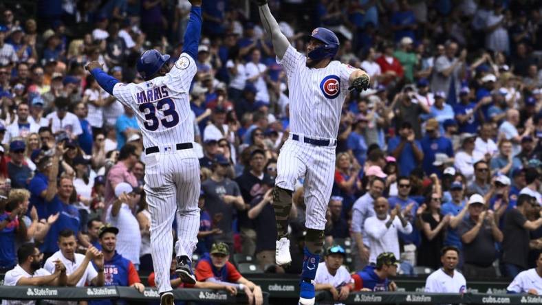 May 20, 2022; Chicago, Illinois, USA;  Chicago Cubs third baseman Patrick Wisdom (16) high fives Chicago Cubs third base coach Willie Harris (33) after he  hits a home run during the second inning against the Arizona Diamondbacks at Wrigley Field. Mandatory Credit: Matt Marton-USA TODAY Sports