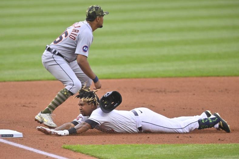 May 20, 2022; Cleveland, Ohio, USA; Cleveland Guardians third baseman Jose Ramirez (11) slides into third base for a triple as Detroit Tigers third baseman Jeimer Candelario (46) covers in the first inning at Progressive Field. Mandatory Credit: David Richard-USA TODAY Sports