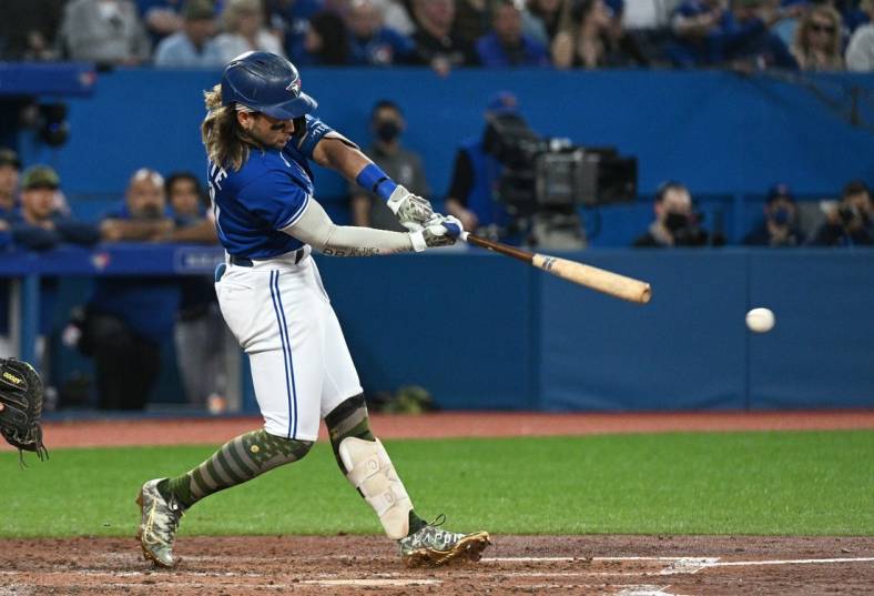 May 20, 2022; Toronto, Ontario, CAN; Toronto Blue Jays shortstop Bo Bichette (11) hits an RBI double against the Cincinnati Reds in the fifth inning at Rogers Centre. Mandatory Credit: Dan Hamilton-USA TODAY Sports