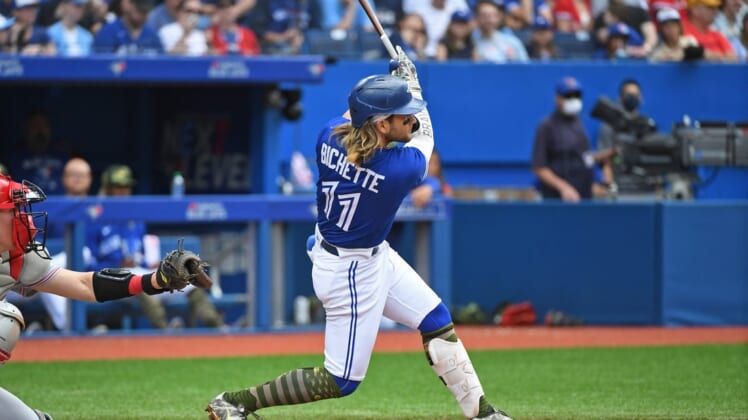 May 21, 2022; Toronto, Ontario, CAN; Toronto Blue Jays short stop Bo Bichette (11) hits a solo home run in the fourth inning against the Cincinnati Reds at Rogers Centre. Mandatory Credit: Gerry Angus-USA TODAY Sports