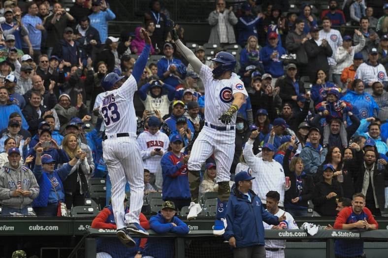 May 21, 2022; Chicago, Illinois, USA; Chicago Cubs third baseman Patrick Wisdom (16), high fives Chicago Cubs third base coach Willie Harris (33) after hitting a home run against the Arizona Diamondbacks during the second inning at Wrigley Field. Mandatory Credit: Matt Marton-USA TODAY Sports