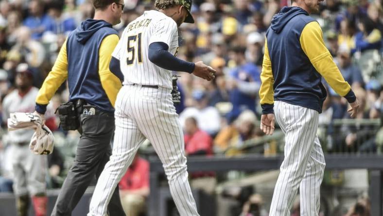 May 22, 2022; Milwaukee, Wisconsin, USA;  Milwaukee Brewers pitcher Freddy Peralta (51) leaves the game with manager Craig Counsell after experiencing right shoulder tightness in the fourth inning during game against the Washington Nationals at American Family Field. Mandatory Credit: Benny Sieu-USA TODAY Sports